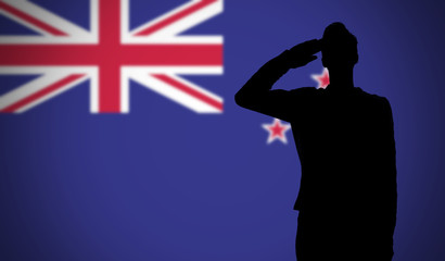 Silhouette of a soldier saluting against the new zealand flag