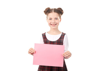 Fototapeta premium Portrait of smiling girl in school uniform holding blank paper against white background