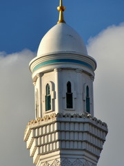 Spitze des Minaretts und der Kuppel der Hazrat-Sultan-Moschee in Astana vor blauem Himmel mit...