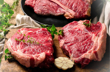 Raw beef meat on a dark wooden board.