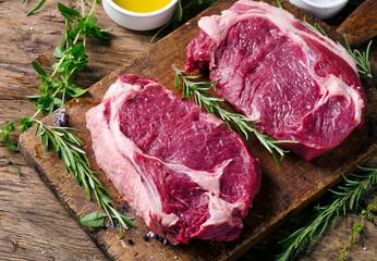 Raw meat Ribeye Steak with seasoning  on dark wooden background