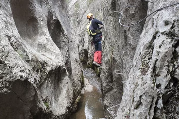 Cercles muraux Alpinisme guy cheking une via ferrata sur une rivière