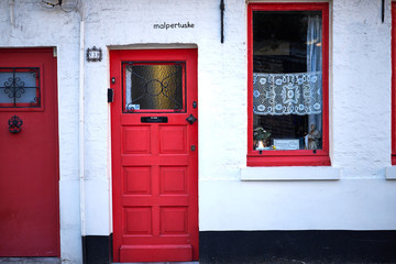 Facciata di casa con porta e finestra dipinte in rosso