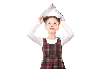 Portrait of cute girl in school uniform having fun with book against white background