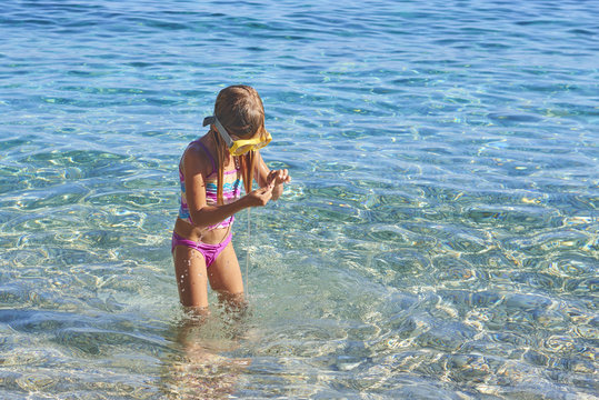 Child little girl wearing diving goggles in the sea. Portrait of a cute girl wearing a goggles for diving background of the sea
