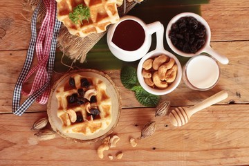 Waffles topped with honey, raisins and cashews.