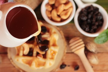Waffles topped with honey, raisins and cashews.
