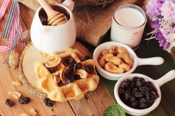 Waffles topped with honey, raisins and cashews.