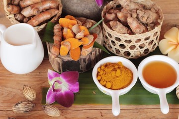 Turmeric root with turmeric powder on wood background