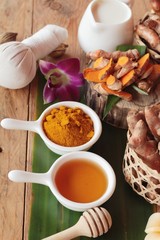 Turmeric root with turmeric powder on wood background