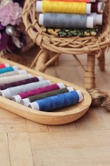Fototapeta na wymiar Colorful thread for sewing on wood background