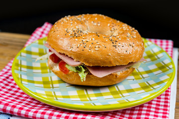 Bagel with fresh cheese and fresh lettuce on napkin