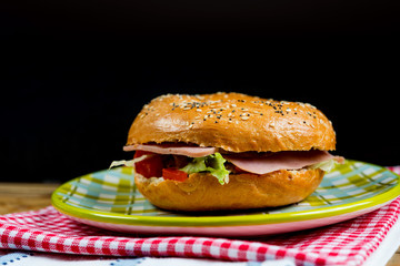 Bagel with fresh cheese and fresh lettuce on napkin