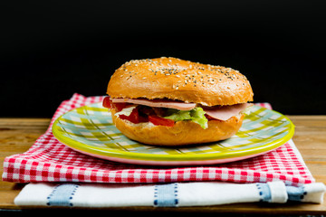 Bagel with fresh cheese and fresh lettuce on napkin