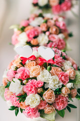Flower arrangement of white and pink roses at the windowsill. Wedding ceremony