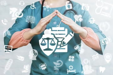 Medical Insurance concept. Doctor holds hands over shield scales clipboard pencil icon on a virtual...