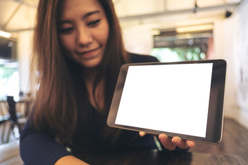 Mockup image of a business woman holding and showing black tablet with blank white screen in cafe