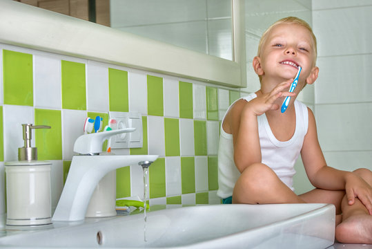 Little boy brushing his teeth in the bathroom.The beginning of a new day - Powered by Adobe