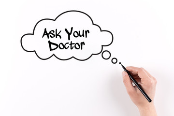 Hand writing Ask Your Doctor on white paper, View from above