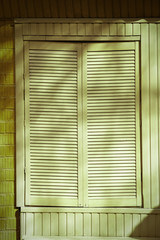 Window with closed blinds on green building