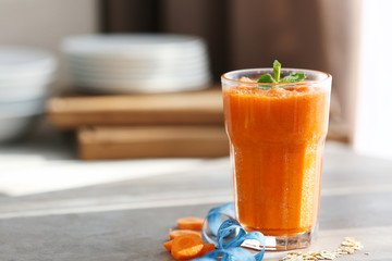 Glass with fresh tasty carrot smoothie on table