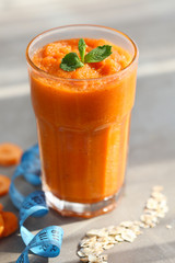 Glass with fresh tasty carrot smoothie on table
