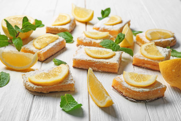 Delicious lemon pie bars on wooden background
