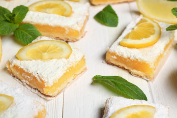 Delicious lemon pie bars on wooden background