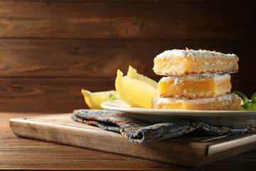 Delicious lemon pie bars stack on wooden background,close up
