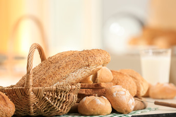Basket with delicious bread on blurred background