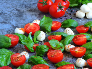 Caprese concept. Cherry tomatoes. Mozzarella balls. Basil. Macro.