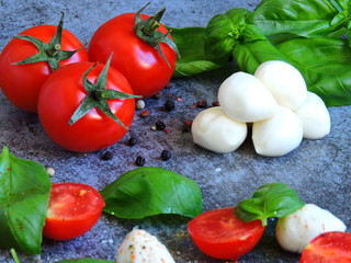 Caprese concept. Cherry tomatoes. Mozzarella balls. Basil. Macro.
