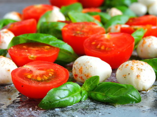 Caprese concept. Cherry tomatoes. Mozzarella balls. Basil. Macro.