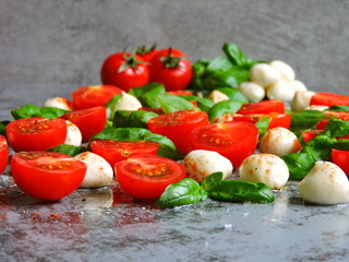 Caprese concept. Cherry tomatoes. Mozzarella balls. Basil. Macro.
