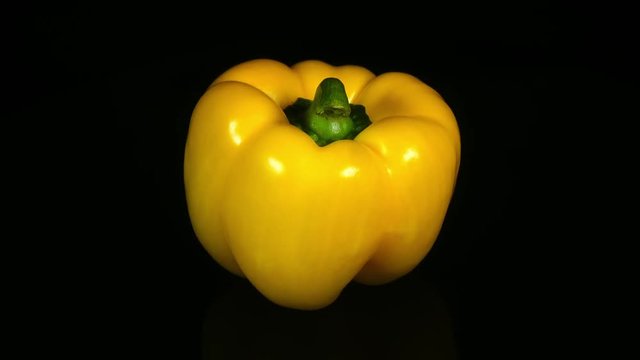 Amazing whole yellow sweet pepper close up, rotating clockwise on black background. Vibrant natural texture of fresh vegetable in 4k, 3840x2160, clip. Excellent eco product for healthy food.

