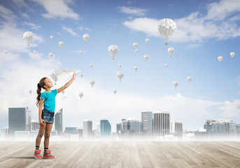 Concept of careless happy childhood with girl dreaming about something