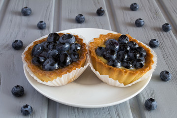 Cakes with blueberries on the grey wooden background   