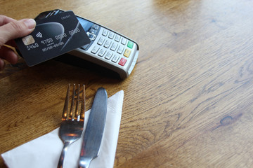 pay tap credit card - contactless payment card pdq background copy space with hand holding credit card to pay