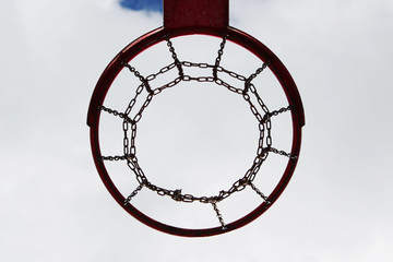 red basketball hoop view from below against the blue sky.