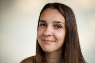 Nude face of cute girl with long hair and brown eyes, no make-up