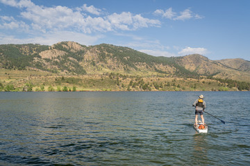 Fototapeta na wymiar summer stand up paddleboard on lake in Colorado