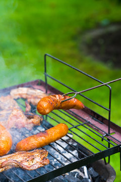 BBQ in the garden - selection of meat on flaming grill