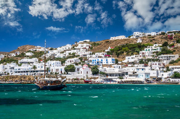 Fototapeta na wymiar MYKONOS, GREECE - JULY 4, 2017: Beautiful view of Mykonos town in Cyclades Islands. There are white houses and boats in the old harbor.