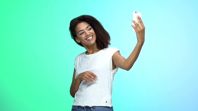 Young pretty african lady make selfie by phone isolated