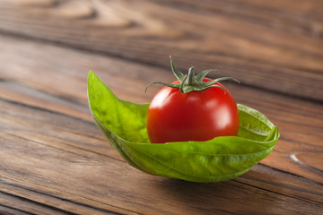 cherry tomato with basil on a wooden background