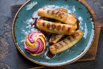 Fried mini bananas served with ice cream on a turquoise plate, horizontal shot