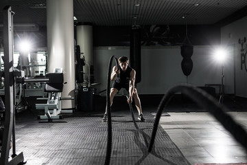 Fitness man working out with battle ropes at gym. Battle ropes fitness man at gym workout exercise...