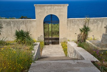 Entrance with wrought iron gate to a graveyard on the island of Stromboli