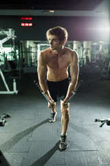 Man doing step up jumps in health club. The man is exercising his legs on the stepper.