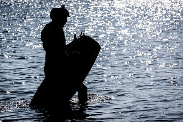 Silhouette of a Man with a Wakeboard coming out of the Water